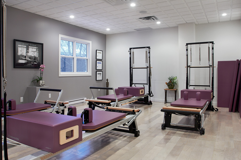 A room filled with purple pilates equipment.